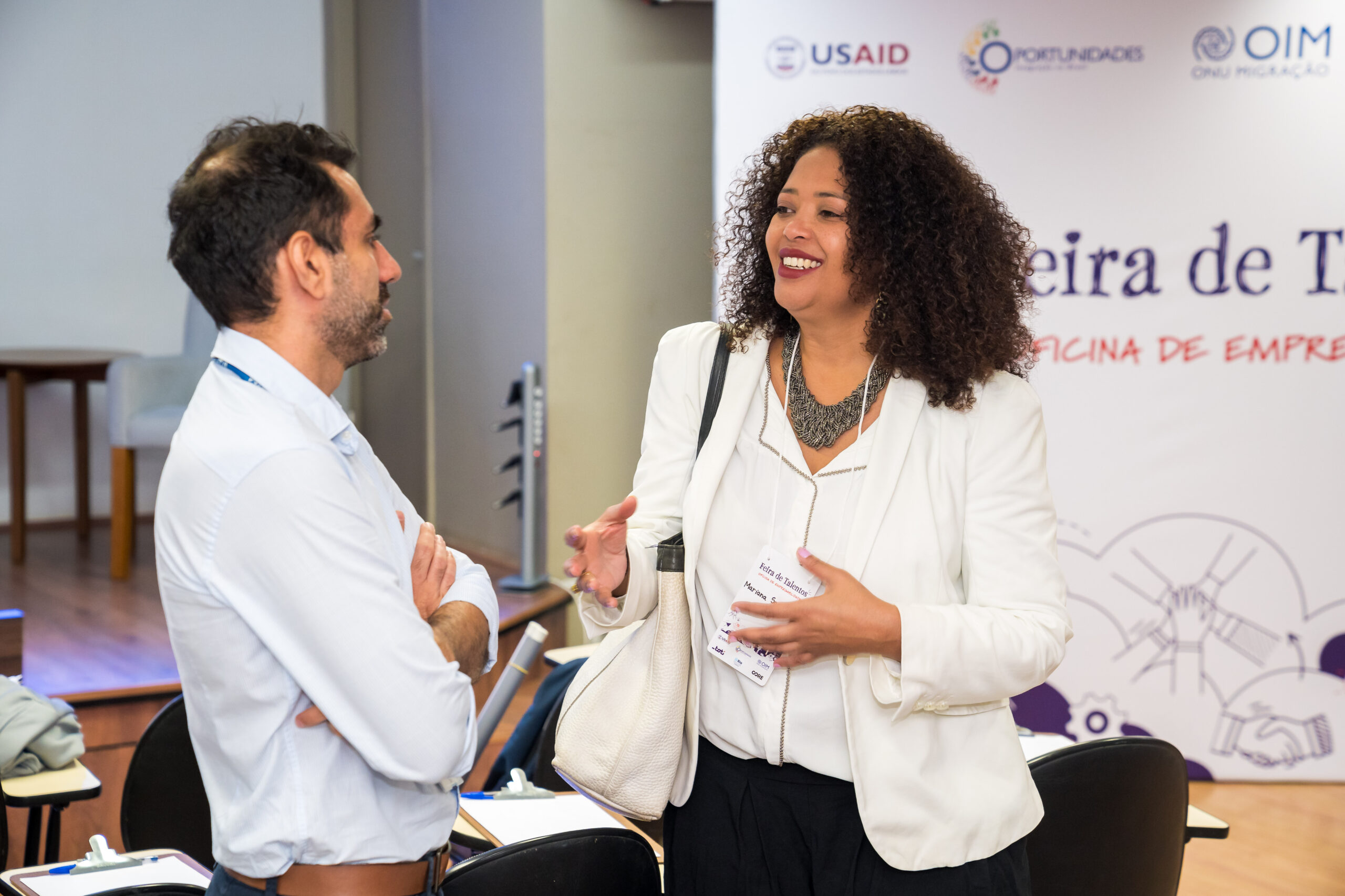 Duas pessoas em conversa durante evento profissional sobre inclusão e respeito no ambiente de trabalho