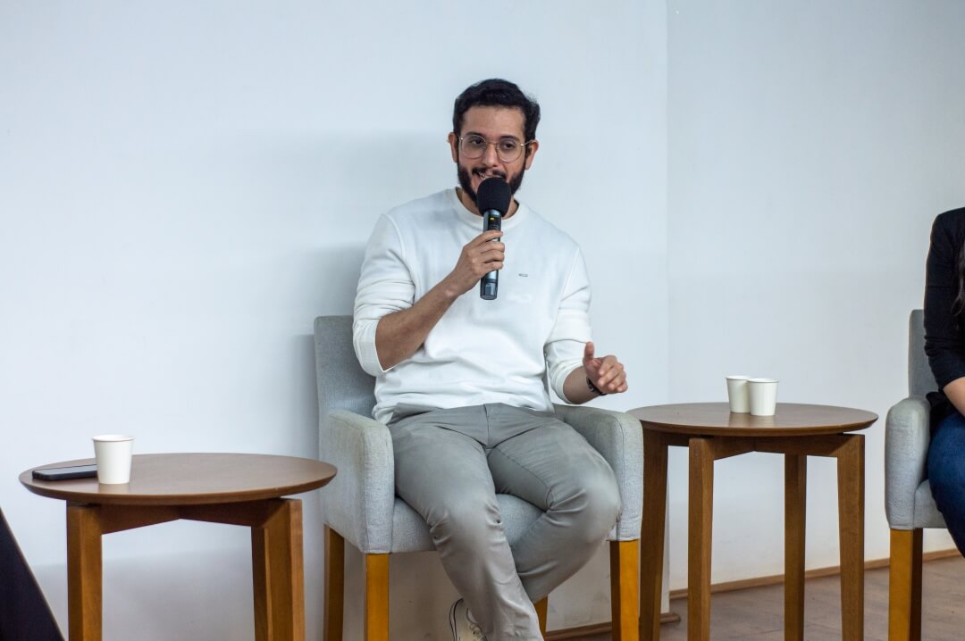 Homem sentado palestrando.