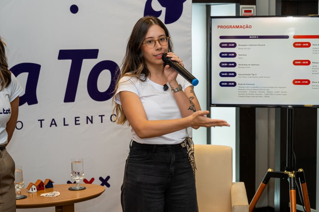 Uma mulher em pé palestrando.