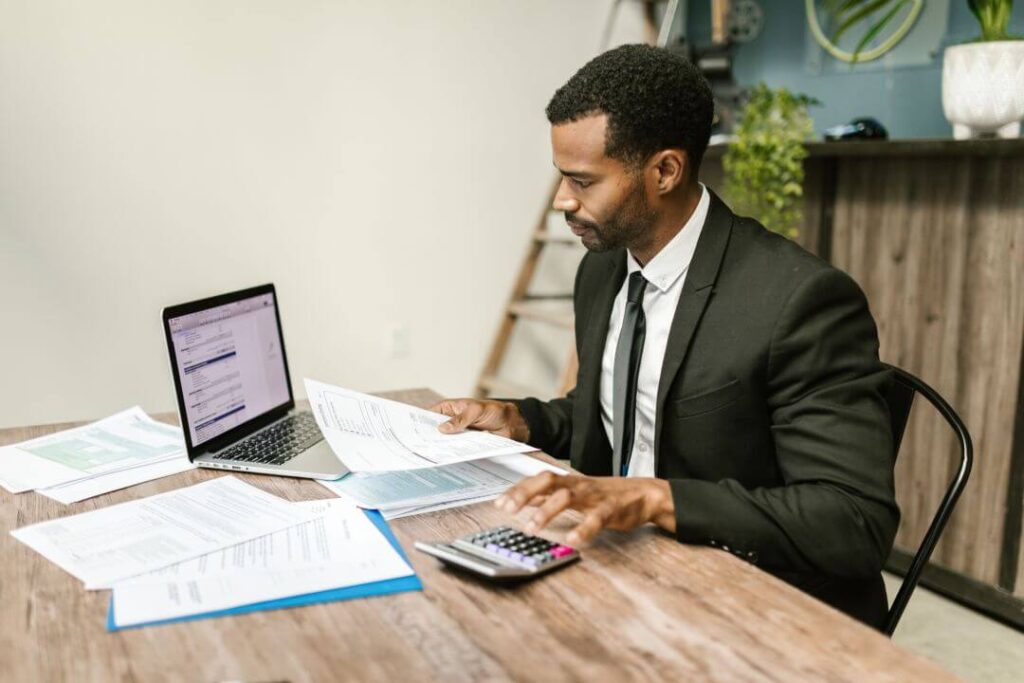 Um homem sentado a mesa trabalhando com um notebook